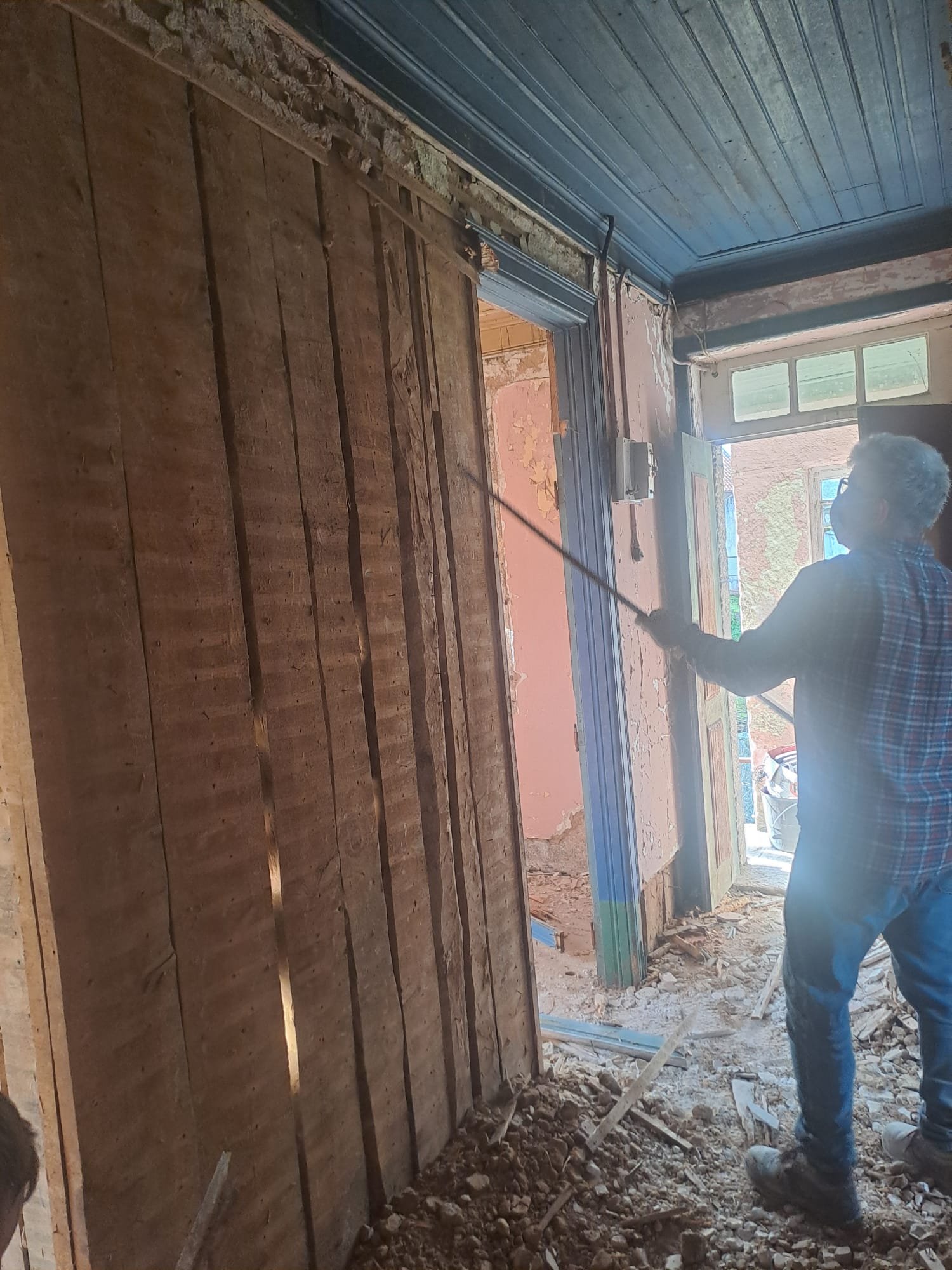 Removing a door frame with a pry bar, doorway open to the courtyard