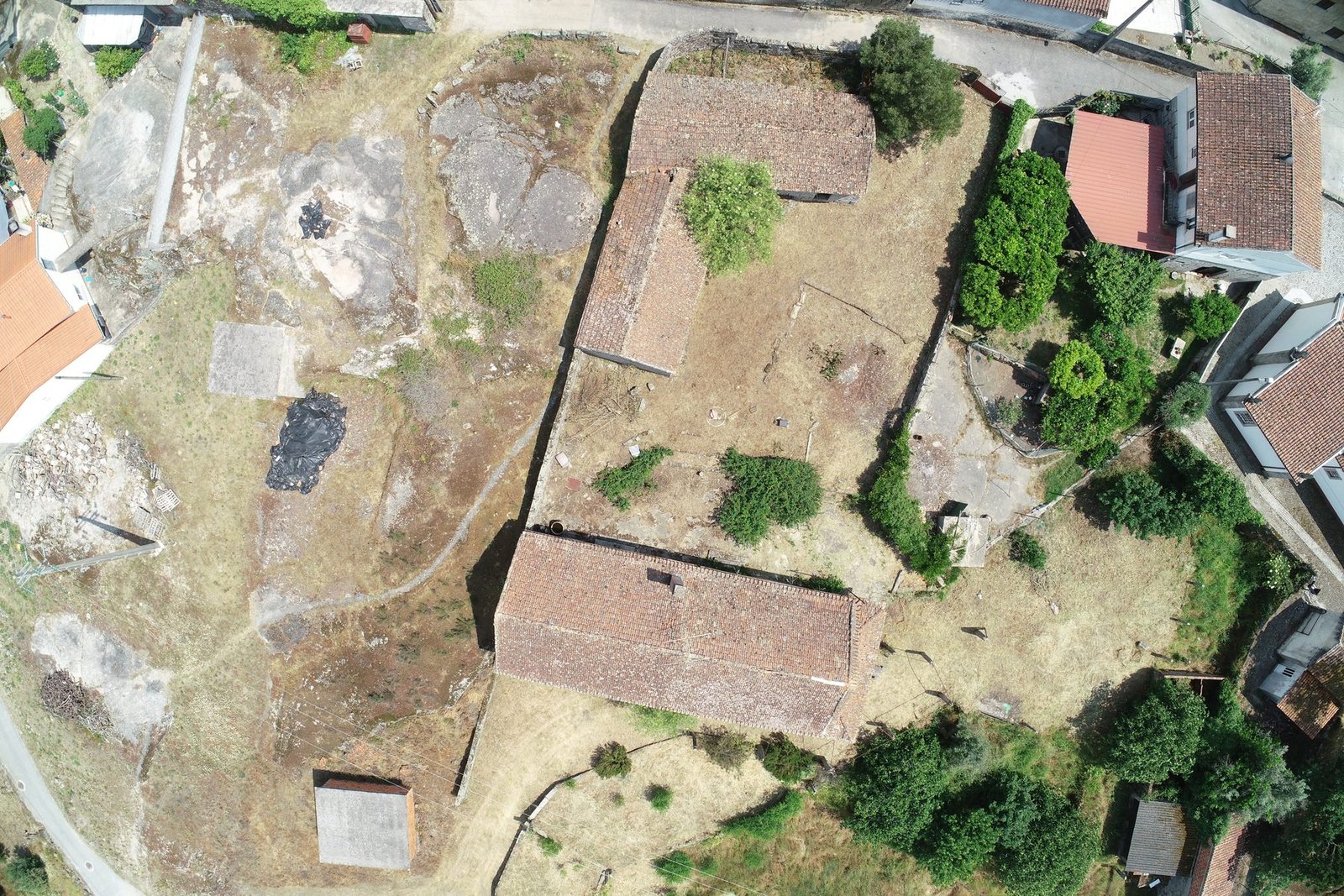 Aerial view of the property, showing the stone buildings and the walled plot